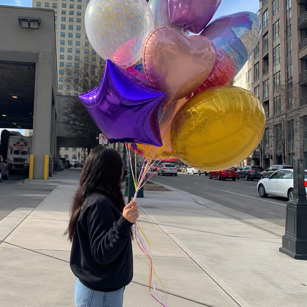 Customer holding a colourful helium balloon bouquet in Toronto